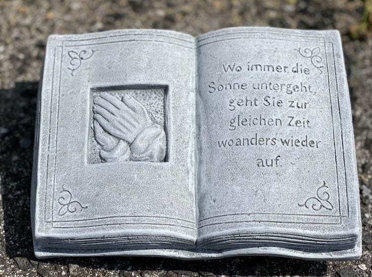 Grabschmuck in Buchform aus Stein mit betenden Händen und deutschem Trauerspruch als dekorative Grabplatte.