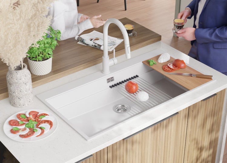 Küchenspüle mit Abtropfgestell, Spülbecken und Armatur auf einer Arbeitsplatte mit Schneidebrett, Zitronen und einer Schale mit Früchten