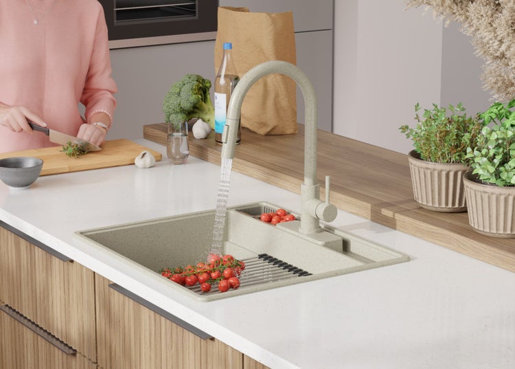 Küchenspüle mit Abtropffläche und Tomaten unter laufendem Wasserhahn