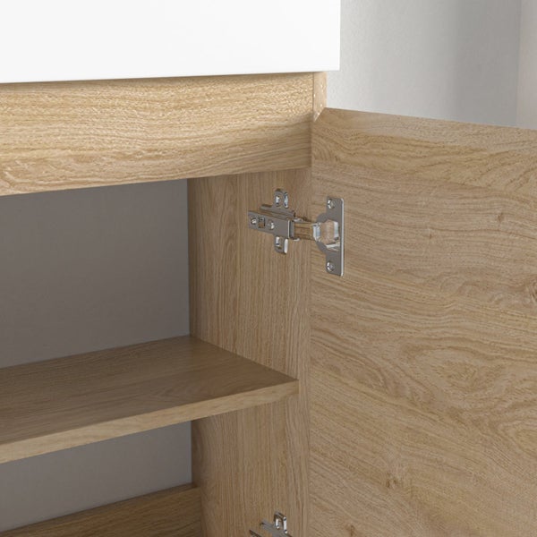 Detailansicht eines Waschbeckenschranks mit Eichenholzoptik und geöffneter Tür mit Metallscharnier.