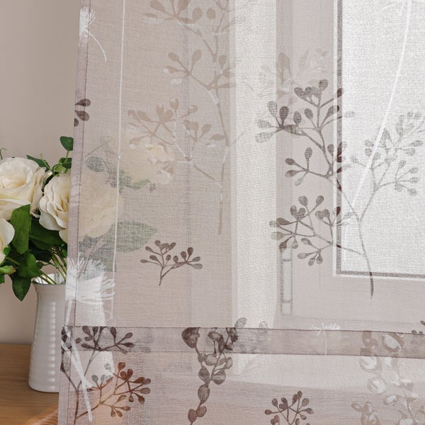 Dekoschals mit Pflanzenmuster neben einer Vase mit Blumen