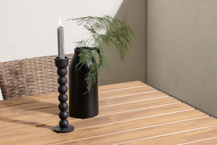 Dekorative Szene mit Kerzenständer, Kerze und Vase auf einem Tisch