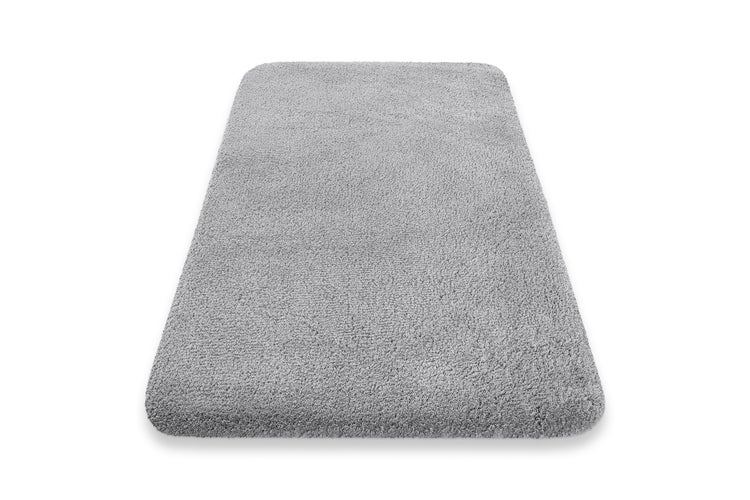 Graue Badematte in rechteckiger Form mit abgerundeten Ecken und weicher Hochflor-Oberfläche.