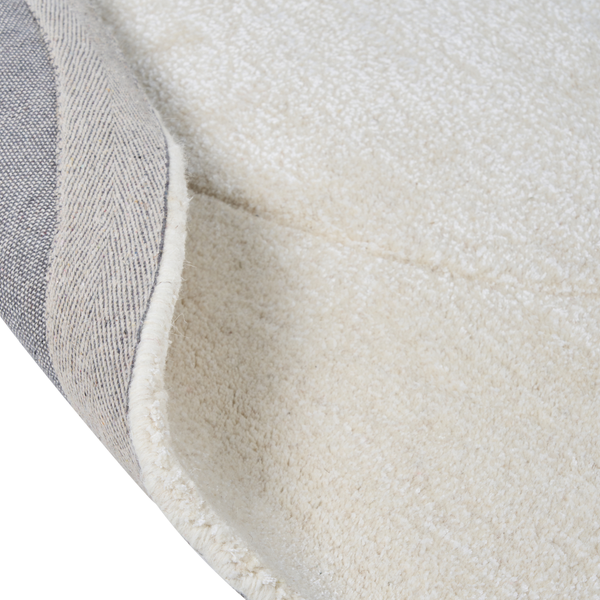 Nahaufnahme eines hellen Teppichs mit gewebter Rückseite