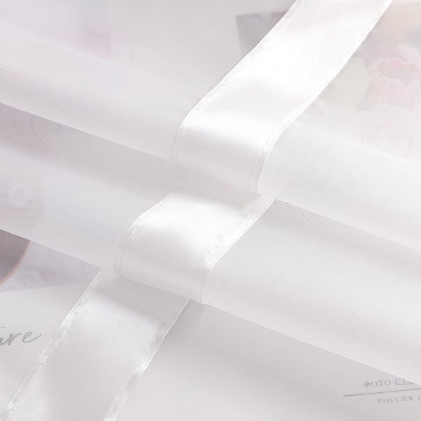 Detailansicht eines weißen, transparenten Gardinenstoffs mit Zierband