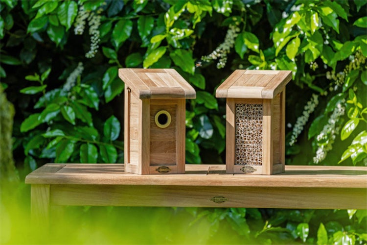 Zwei Insektenhotels aus Holz auf einem Tisch