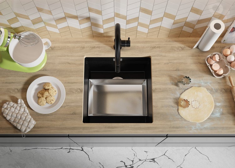 Küchenszene mit Spüle, Armatur, Teig, Ausstechern und Backutensilien auf einer Arbeitsplatte.