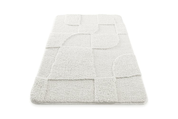 Weiße Badematte mit geometrischem Reliefmuster und abgerundeten Ecken.