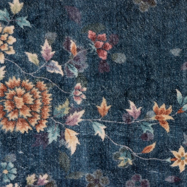 Nahaufnahme eines Teppichs mit floralem Muster und weicher Struktur.