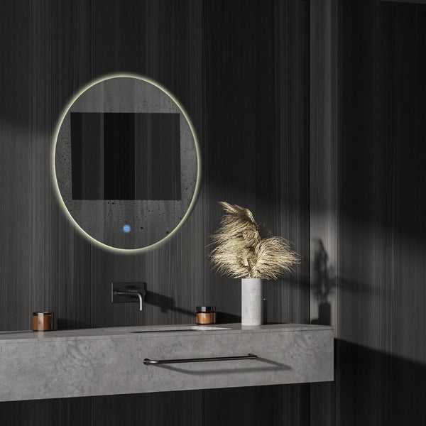 Runder Badezimmerspiegel mit LED Beleuchtung und integriertem Display an einer Wand über einem Waschtisch mit Steinoptik.