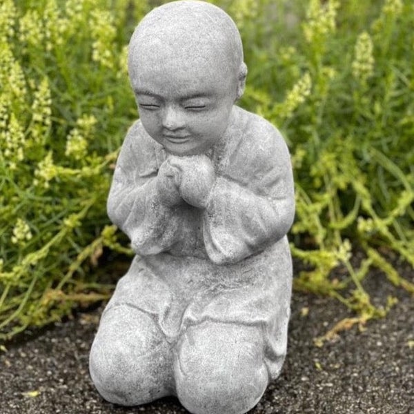 Steinfigur eines betenden Kindes als Dekoration für den Garten