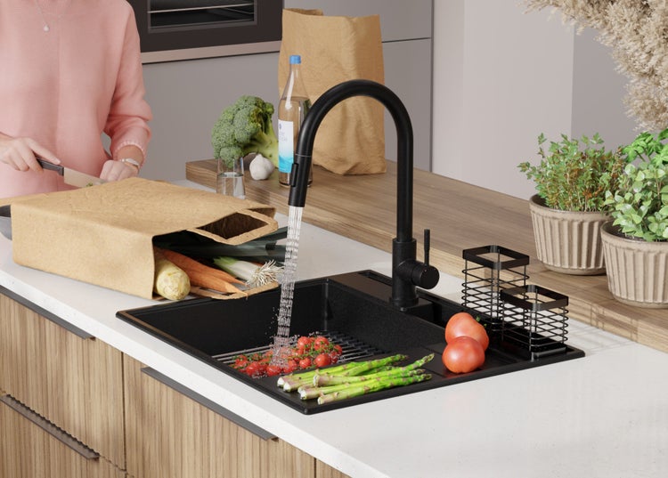 Schwarze Spüle mit Armatur und Gemüse in einer modernen Küche