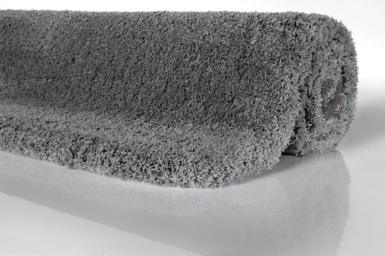 Gerollter Hochflor-Teppich in Grau mit weicher Textur im Shaggy-Stil.