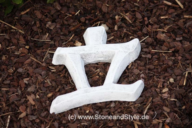 Gartenfigur in Form eines japanischen Schriftzeichens aus Stein auf Rindenmulch.