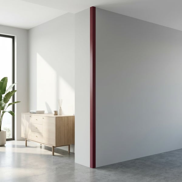 Moderne Wand mit einer vertikalen Eckleiste in einem minimalistisch eingerichteten Raum mit Holzkommode und Pflanze.