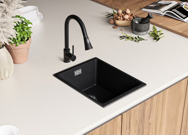 Schwarzes Spülbecken mit Armatur auf einer Küchentheke