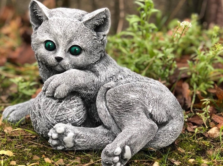 Gartenfigur Katze spielend mit Wollknäuel aus Steinimitat für den Außenbereich.