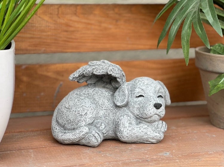 Steinfigur Engelhund in liegender Position aus wetterfestem Kunststein für den Garten oder als Grabschmuck.