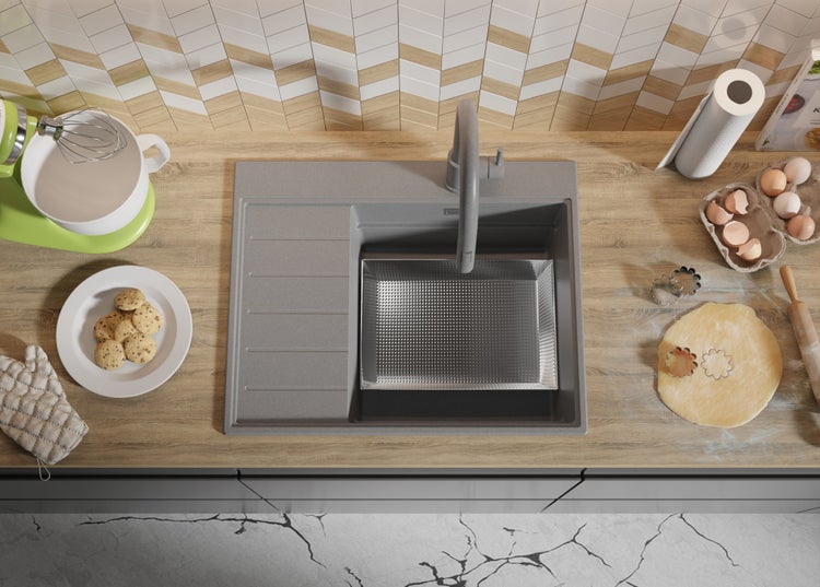 Küchenszene mit Spüle, Rührgerät, Backzutaten und Utensilien auf einer Arbeitsplatte