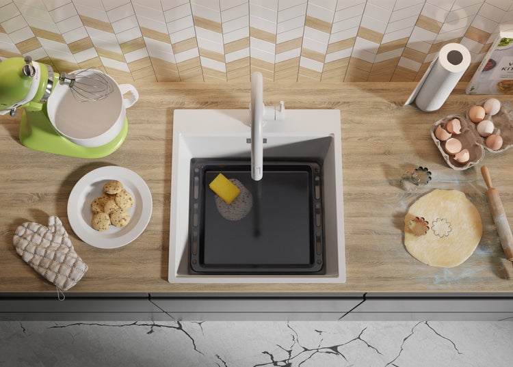 Küchenszene mit Spüle, Armatur, Geschirr und Lebensmitteln zur Zubereitung