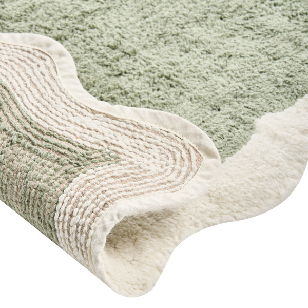 Detailansicht eines grünen Badteppichs mit gewendetem Rand