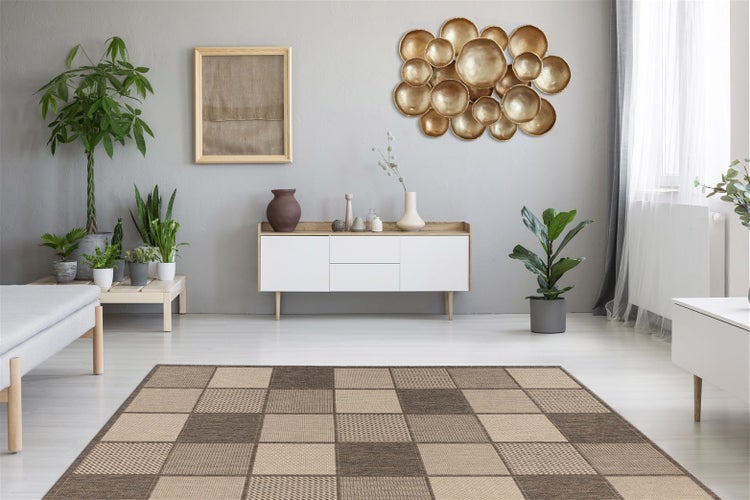 Moderner Wohnraum mit einem braun-beigen Teppich im Karomuster, einem weißen Sideboard, Zimmerpflanzen und einer goldenen Wanddekoration.