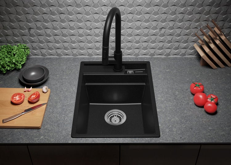 Schwarzes Spülbecken mit Armatur, Spüle und Lebensmitteln auf einer Küchentheke.