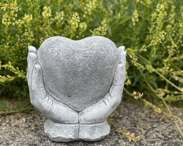 Steinfigur aus Kunststein in Form von zwei Händen, die ein Herz halten, als Dekoration für den Garten.