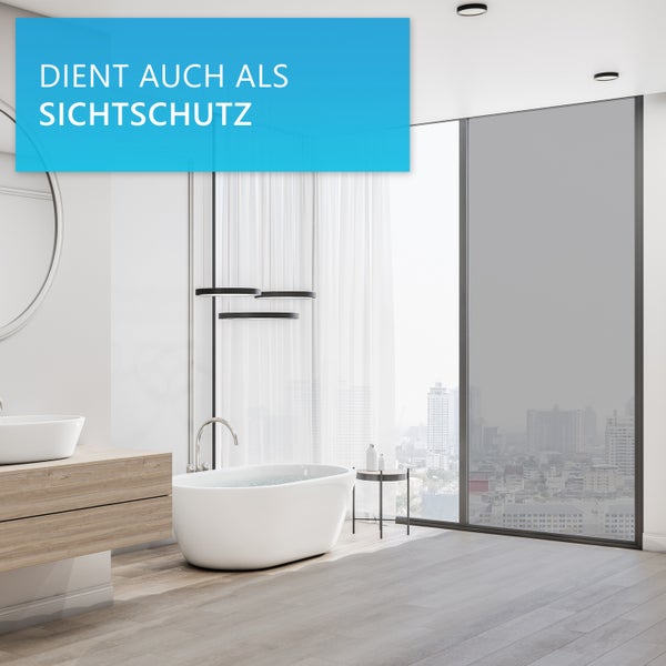 Helles, modernes Badezimmer mit freistehender Badewanne und großem Fenster, das mit einer Sichtschutzfolie versehen ist.