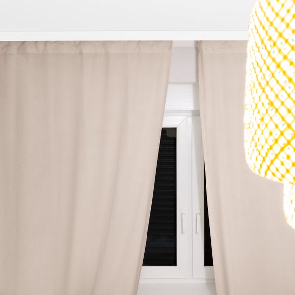 Fenster mit Vorhängen und Jalousien sowie eine leuchtende Lampe