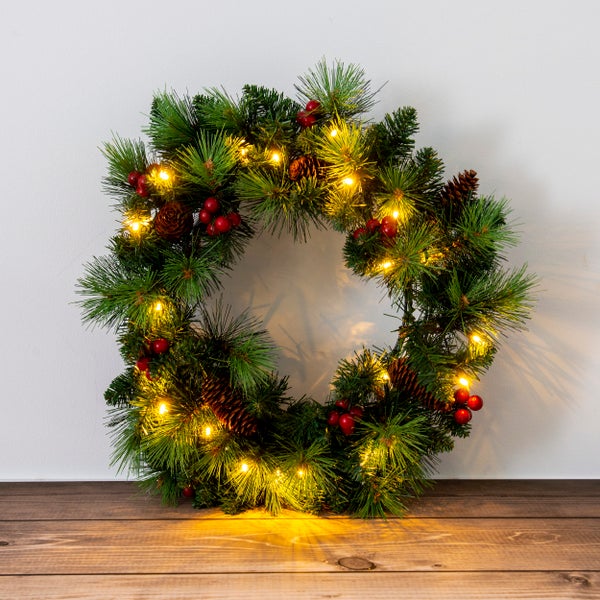 Dekorativer Weihnachtskranz mit Beleuchtung, Tannenzapfen und roten Beeren