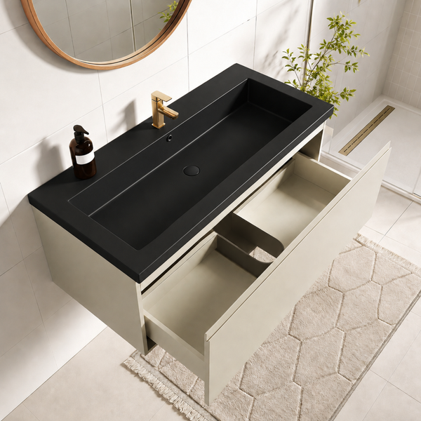 Moderner Waschtisch mit schwarzem Einbauwaschbecken und offener Schublade in hellem Badezimmer mit rundem Spiegel und goldener Armatur.