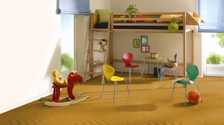 Helles Kinderzimmer mit einem hölzernen Hochbett, mehreren Stühlen, einem Schaukelpferd und Teppichboden.