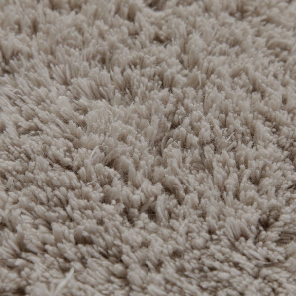 Detailansicht eines hellbeige melierten Hochflor-Teppichs.