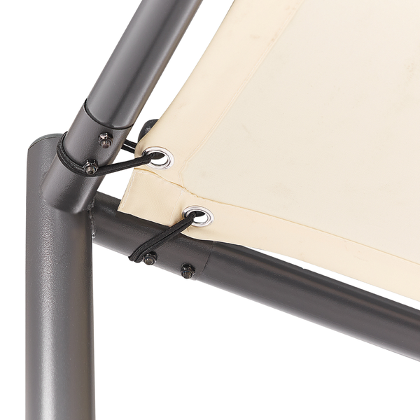 Olivenbaum Olea europaea in Pompon-Form hinter einem Metallzaun in einem hellen Garten mit Wald im Hintergrund.