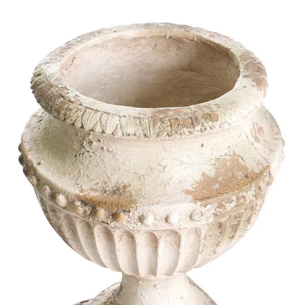 Dekorative Szene mit Sofa, Beistelltisch und einer großen Vase mit Ziergras im Freien.