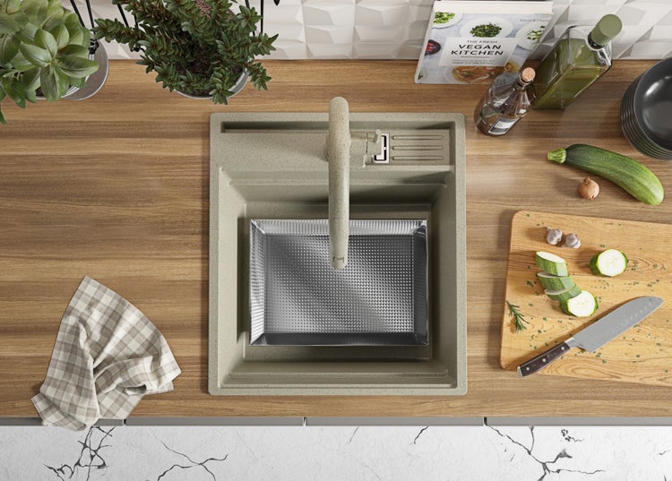 Küchenspüle mit Spültischarmatur, Schneidebrett, Messer und Zutaten in der Küche