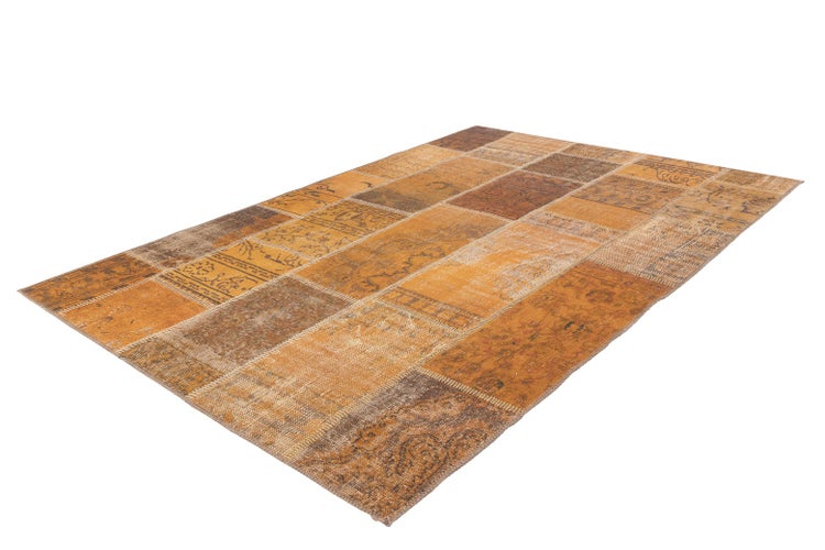 Rechteckiger Patchwork-Teppich mit orientalischen Mustern in Braun und Orange.