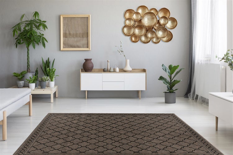 Hell eingerichtetes Wohnzimmer mit braunem gemustertem Teppich, weißem Sideboard, Zimmerpflanzen und goldener Wanddekoration.