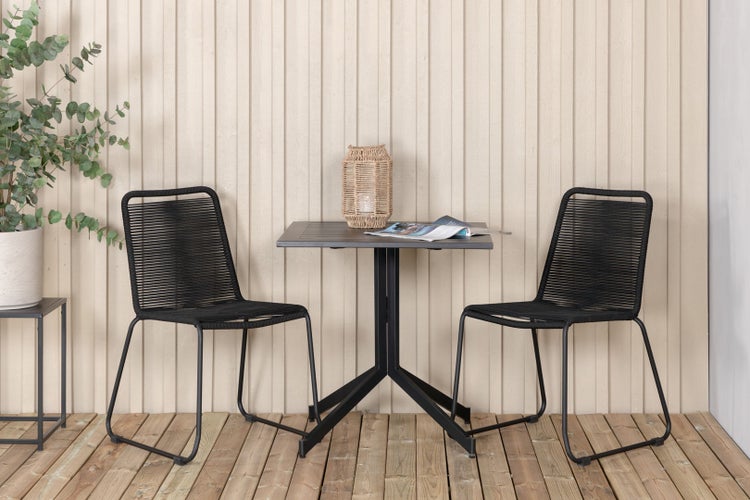 Gartenszene mit Tisch, zwei Stühlen und Dekoration auf einer Holzterrasse