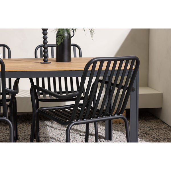 Gartenszene mit Esstisch und Stühlen im Außenbereich.