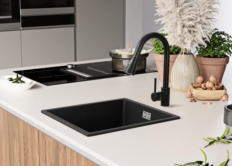 Küchenspüle mit schwarzer Armatur und Spülbecken auf einer hellen Arbeitsplatte.