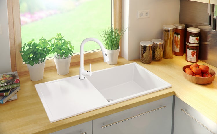 Küchenspüle mit Abtropffläche und Armatur in einer hellen Küche.