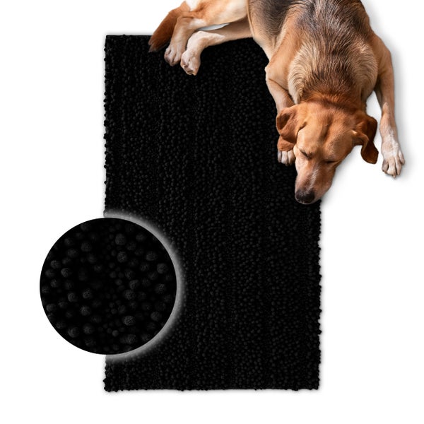 Schwarze Hundematte mit Noppenstruktur und liegendem Hund, Detailansicht der weichen Oberfläche.