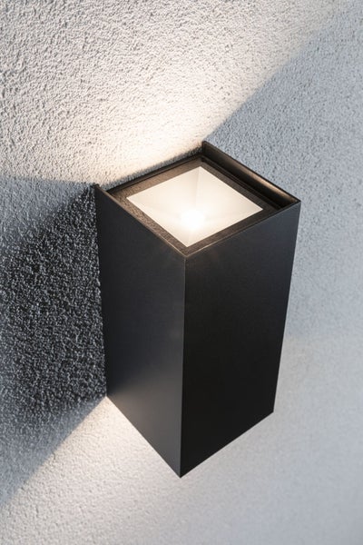 Moderne rechteckige Wandleuchte für den Außenbereich mit Lichtaustritt nach oben und unten an einer strukturierten Wand.