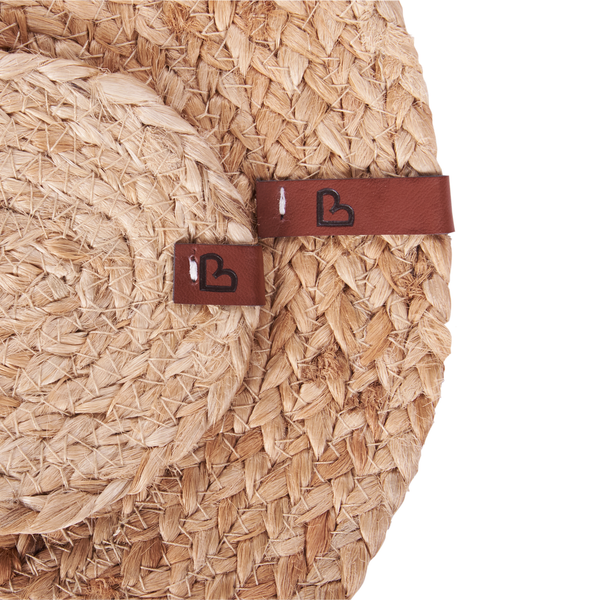 Detailaufnahme eines geflochtenen Untersetzers aus Naturfasern mit Lederetikett