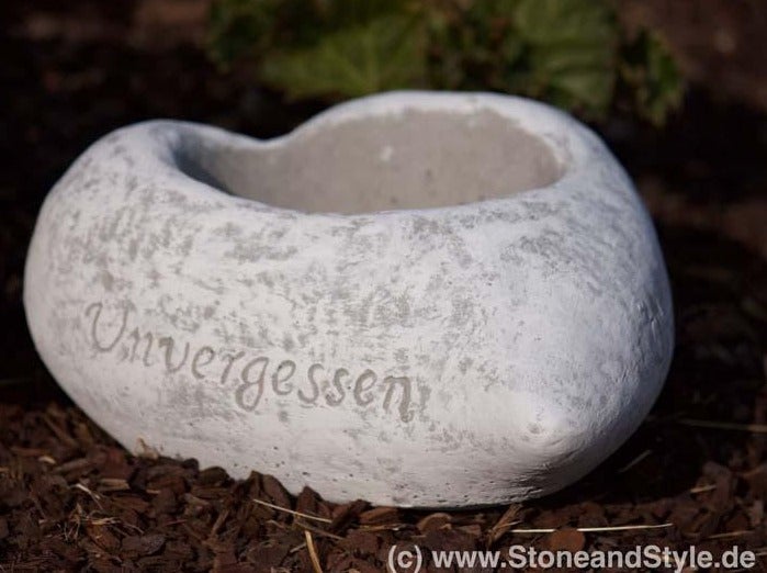 Herzförmige Pflanzschale aus Beton mit der Inschrift Unvergessen für die Grabgestaltung.