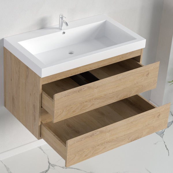 Wandhängender Waschtischunterschrank mit weißem Waschbecken, Armatur und zwei offenen Schubladen in heller Holzoptik.