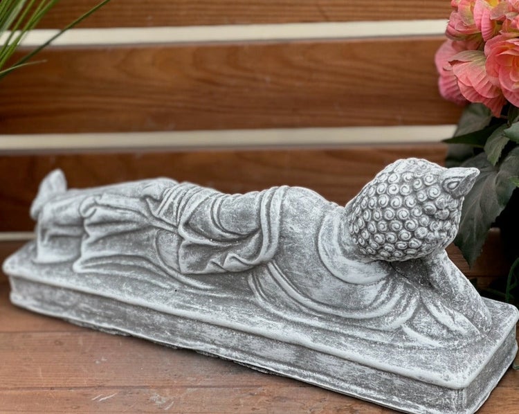 Liegende Buddha-Statue aus Steinguss als Gartendekoration.