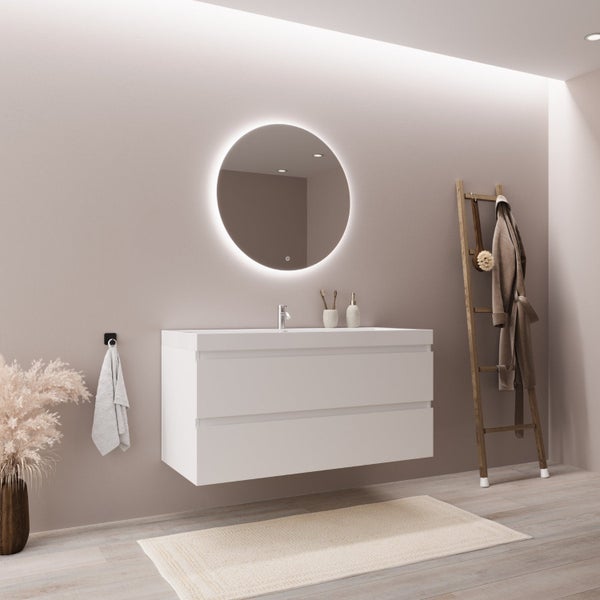 Modernes Badezimmer mit weißem wandhängendem Waschbeckenunterschrank, beleuchtetem runden Spiegel, Handtuchleiter aus Holz und Badaccessoires.